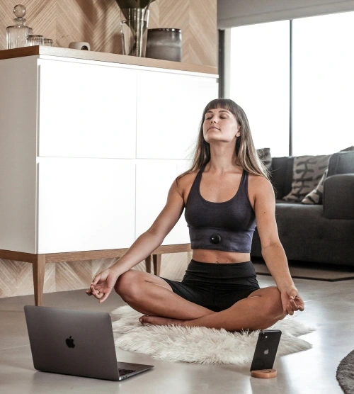 Woman meditating with a breathwork session on her laptop